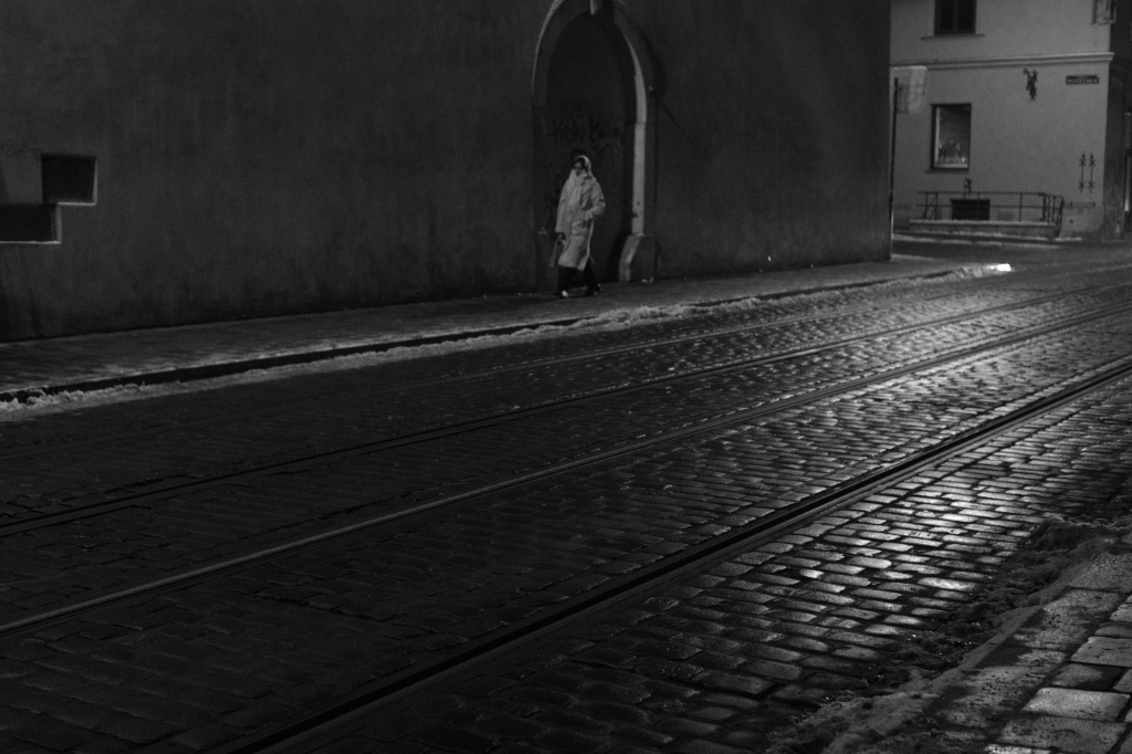 A woman walking down an empty street.
