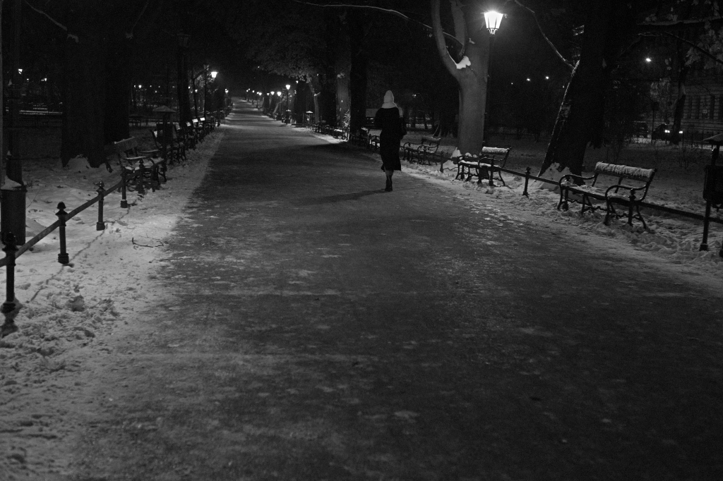 A woman walking down an empty pathway.