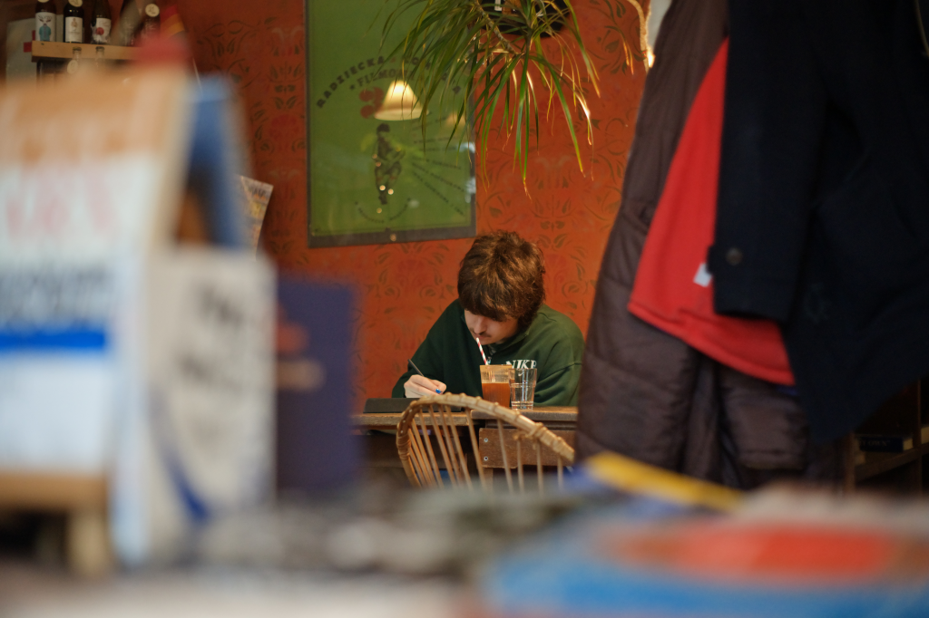 A young man sitting in a book café, studying for his math classes.